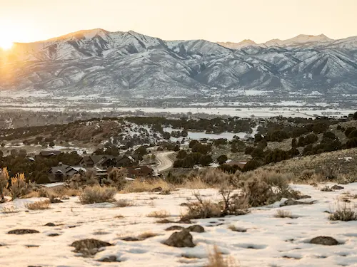 Heber Utah valley with snow covered mountain range at sunrise with residential area below